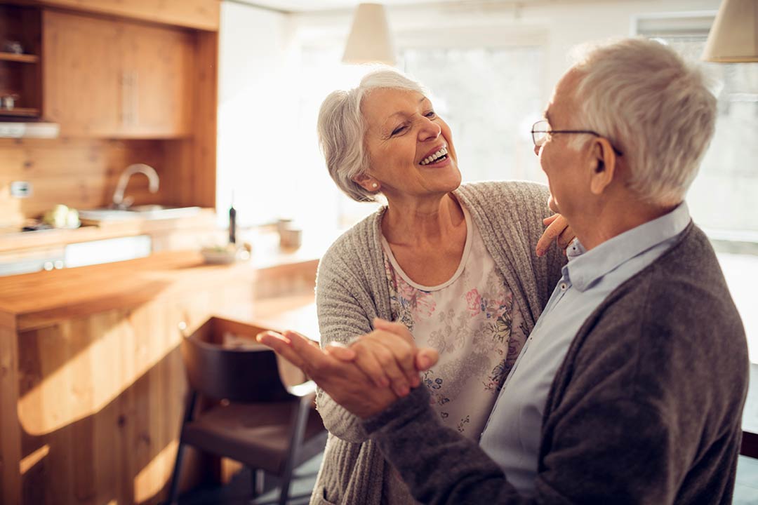 retired couple dancing in home