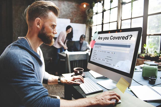 A business person reviewing their business insurance coverage on the computer